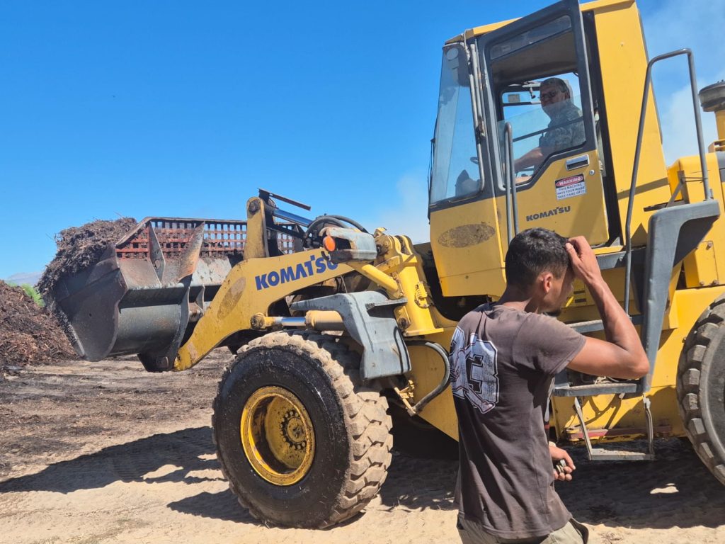 The farm owner assists with his digger
