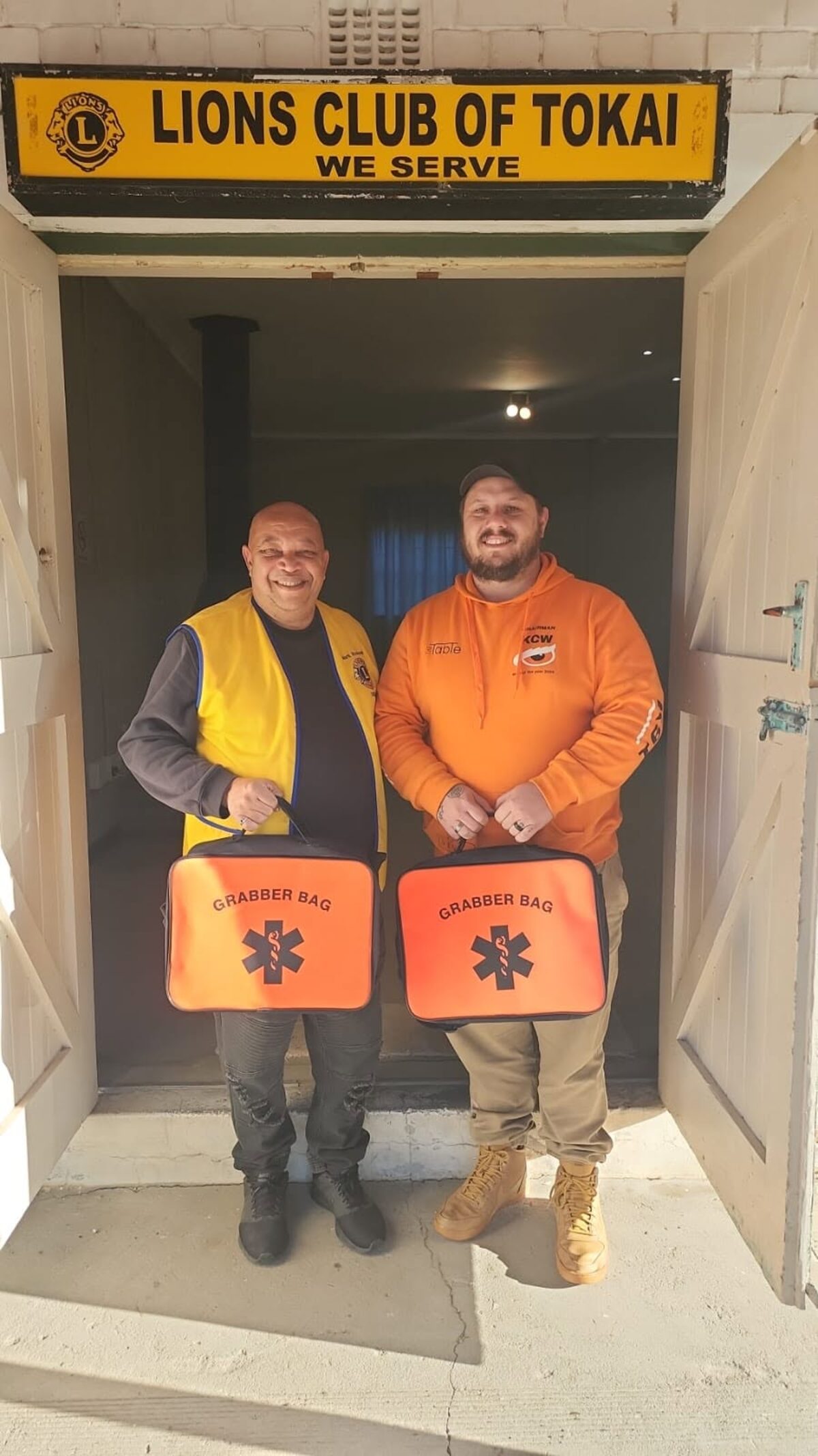 Mark Rossouw president of Lions Club of Tokai receives two first-aid kits from Kirstenhof Crime Watch chair Kyle Clark