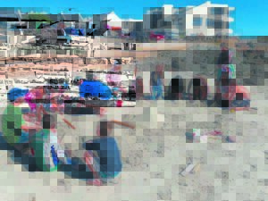 Kids having fun learning to sculpt sand in Bloubergstrand