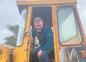 Man spring op laaigraaf om te help toe water by huis in Brackenfell inloop