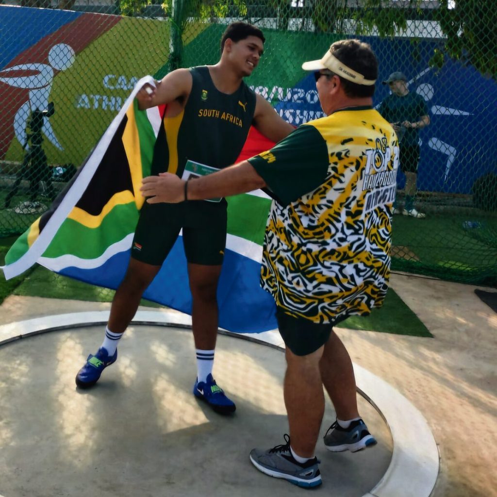 Eben Jacobs word deur sy afrigter, Leon Spies geluk gewens Saterdag na afloop van die o.20 mans-hamergooi.