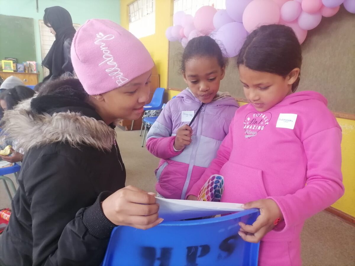 Volunteer Enza Brevis chats to Shay-Lee Abrahams and Sulaygah de Vos.