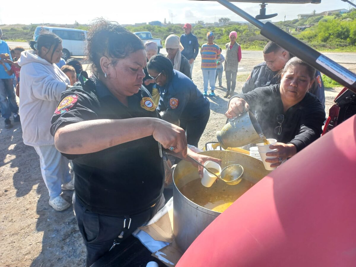 Firefighters from Mitchell's Plain Fire Station hand out cups of soup and bread at Sewende Laan informal settlement in Strandfontein.