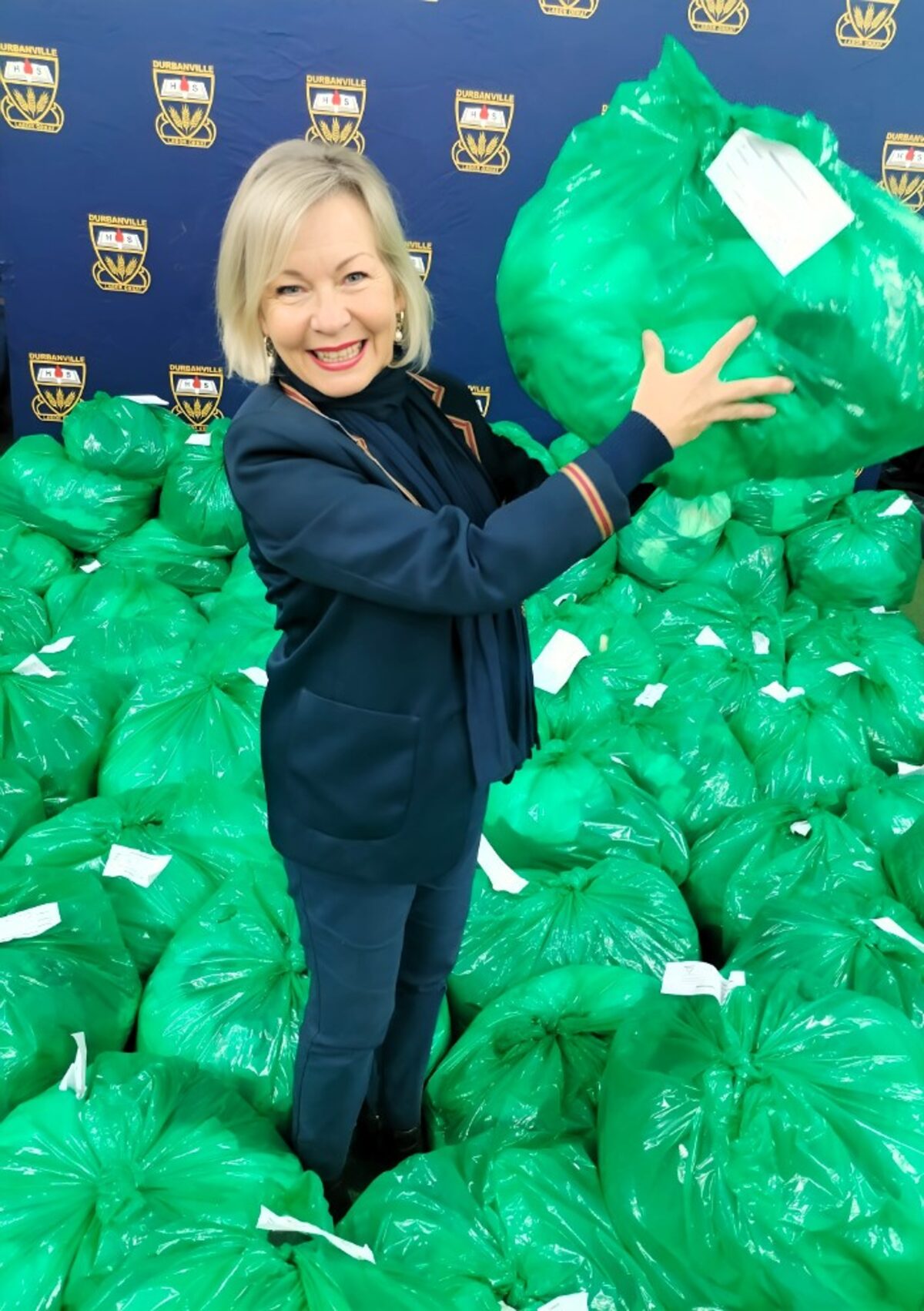 Annemarie Stoffberg beams with pride among the collected bags, holding one of the 86 bags.