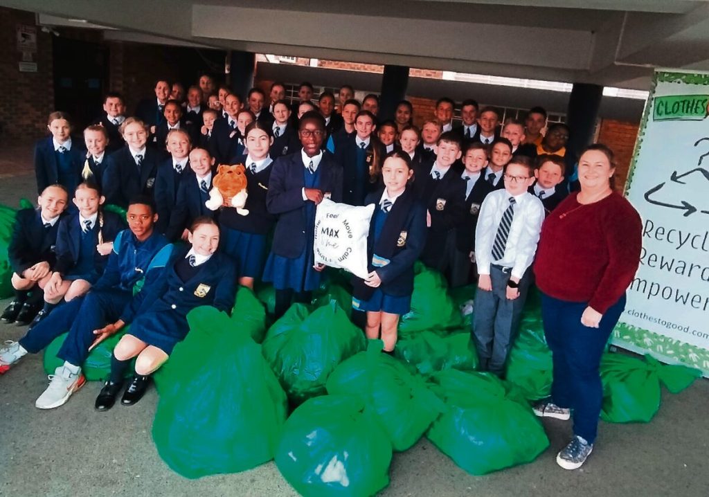 Leerders van die Laerskool Durbanville by die altesame 93 sakke propvol klere, komberse, kussings en sagte speelgoed wat hulle tydens die skoolvakansie ingesamel het.