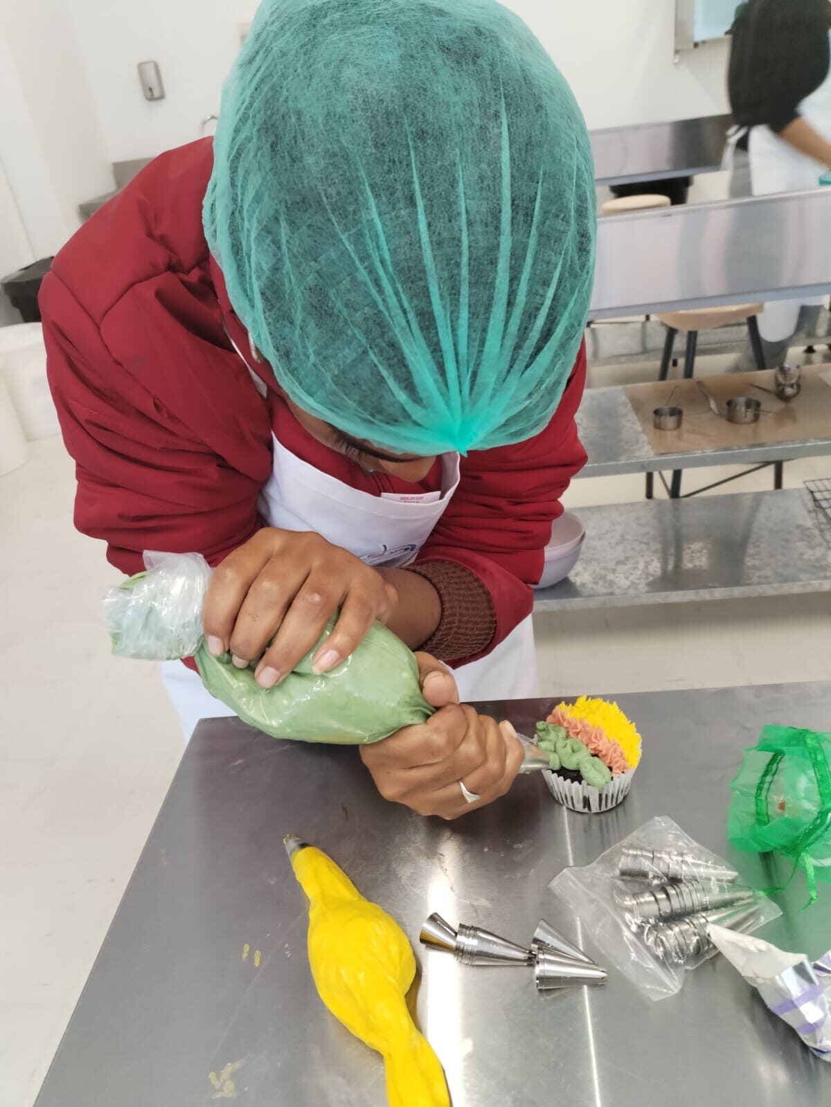 A pupil decorates cupcakes during the TCM Skills Centre patisserie design course.