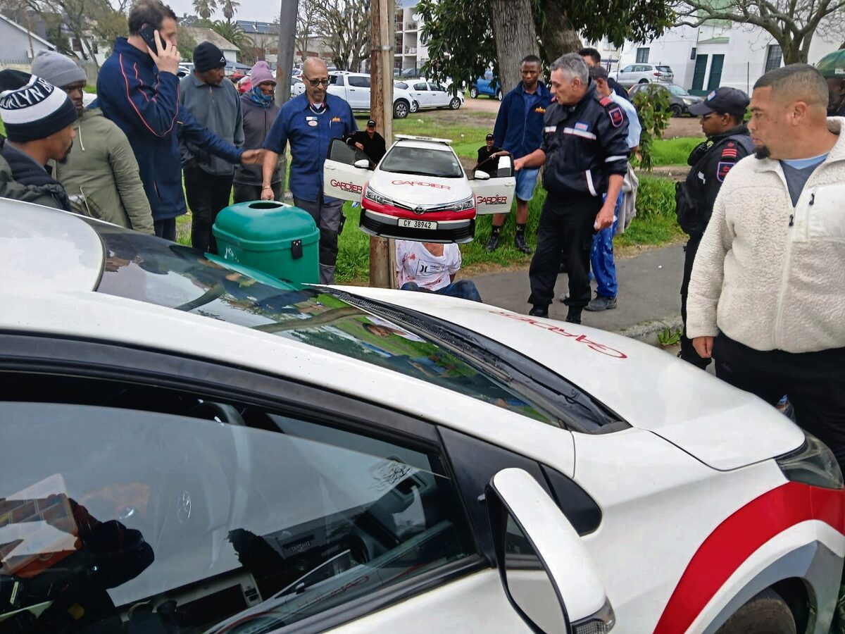 Sekerheidsbeamptes van Gardier Security Services en omstanders staan by die verdagte waar hy aangekeer is. Foto: Facebook