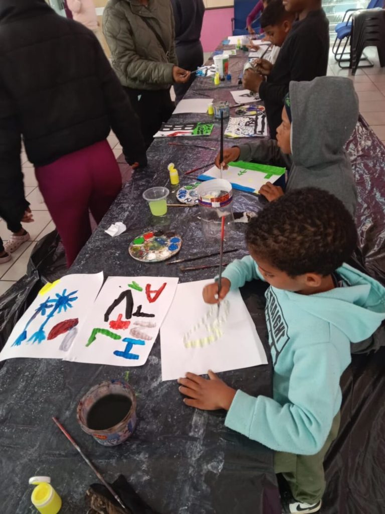 Children paint at the Mark Jeneker foundation art therapy holiday programme at Town Centre Library.