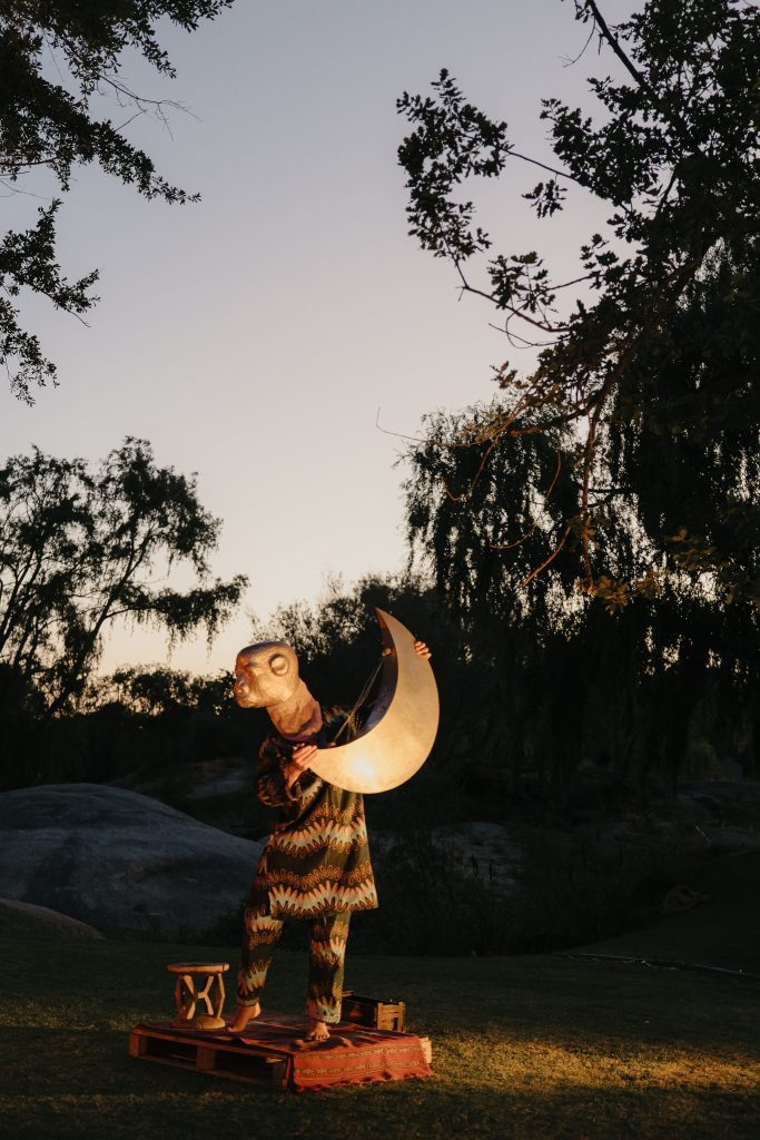 Photo of a figure holding a half moon
