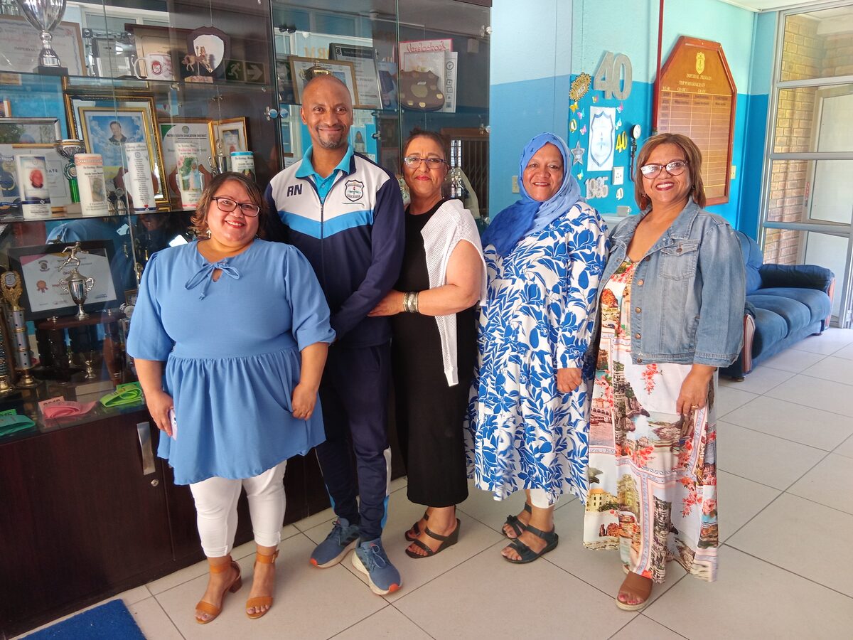 Imperial Primary's longest serving teachers pose before the trophy cabinet.