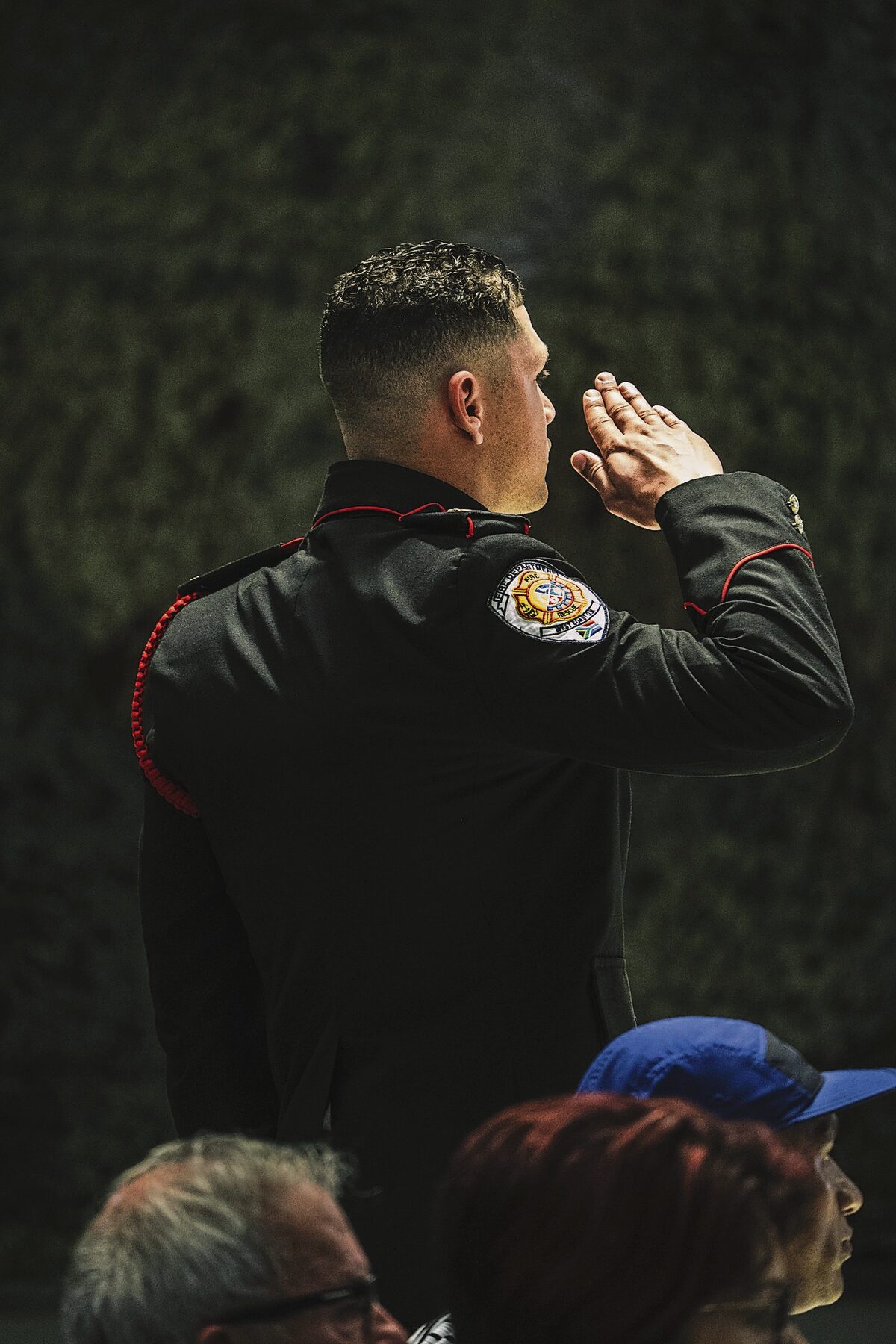 A graduate stands tall, saluting during the graduation.