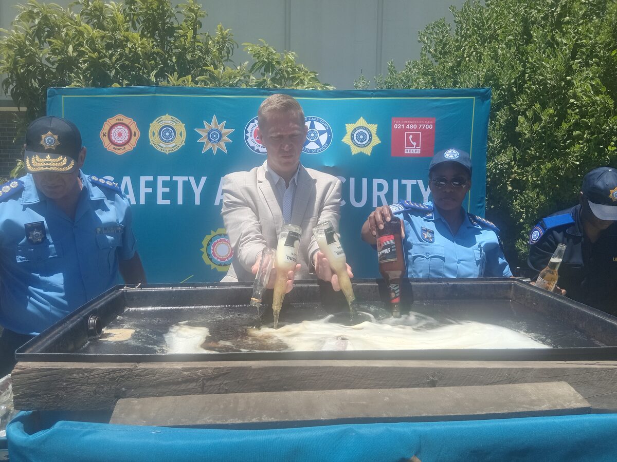 JP Smith and Law Enforcement officers dispose of thousands of liters of confiscated booze.