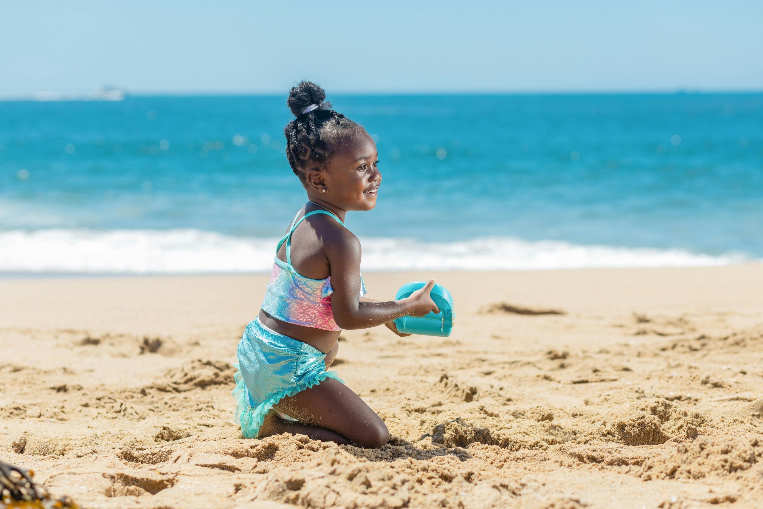 Foto van 'n meisie wat speel op die strand.
