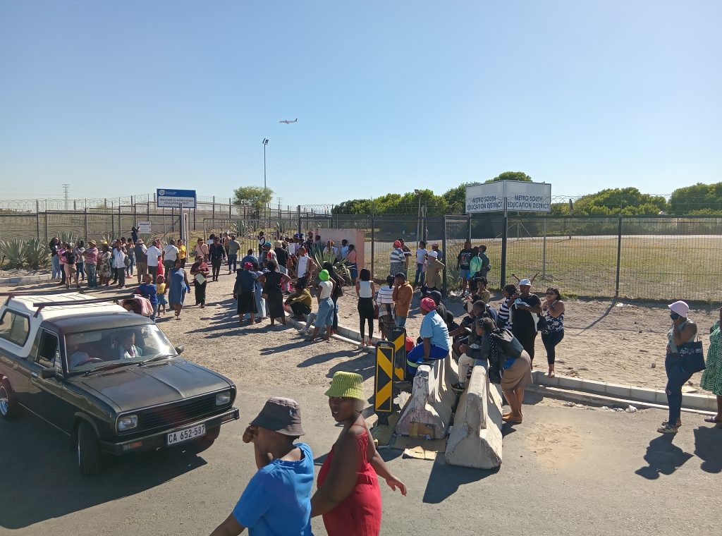 Parents queue outside the Metro South Education District office to try to get their children placed at schools. 
