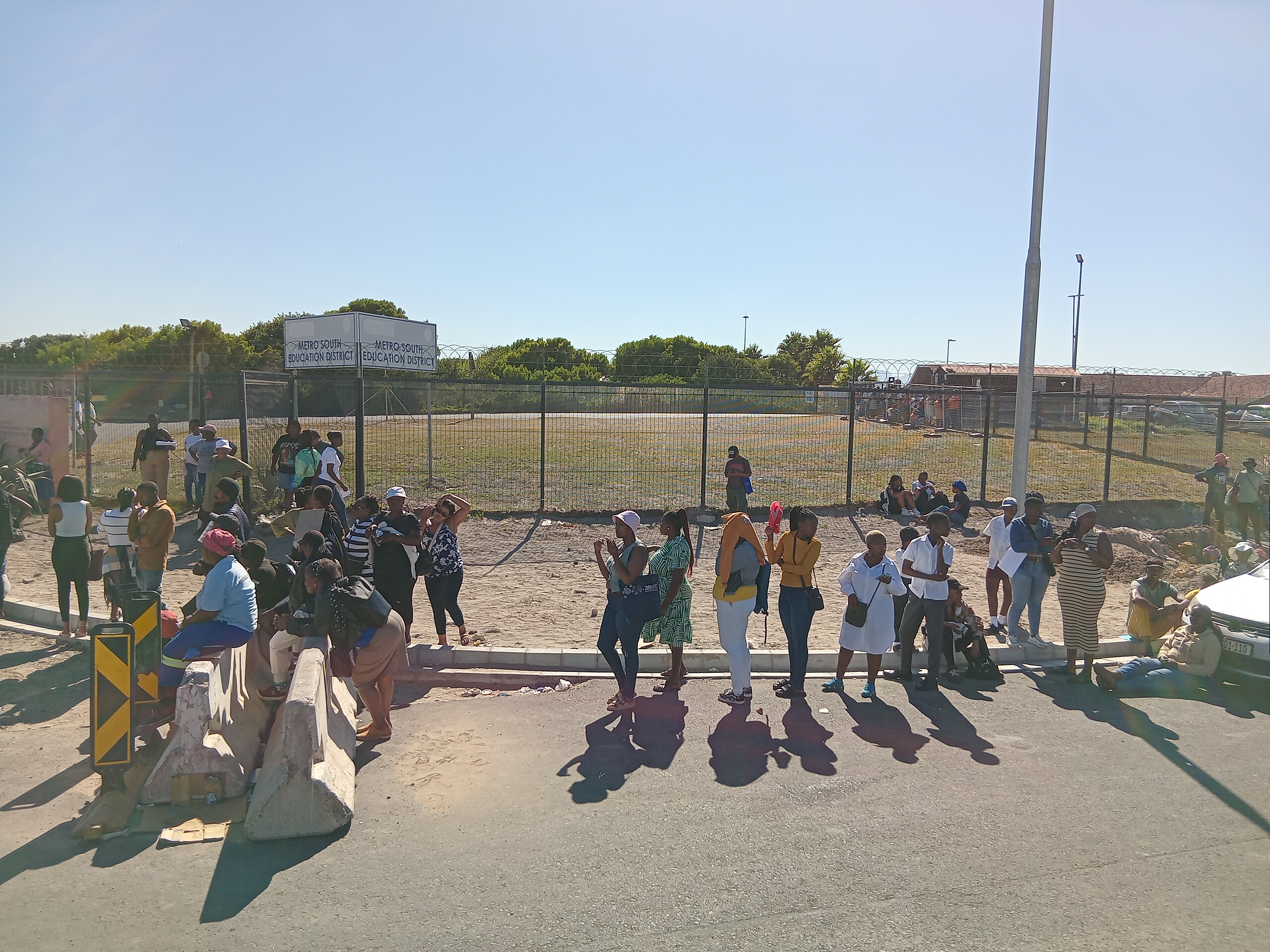 A long queue of people who need their children placed at schools snakes around the Metro South Education District Building.