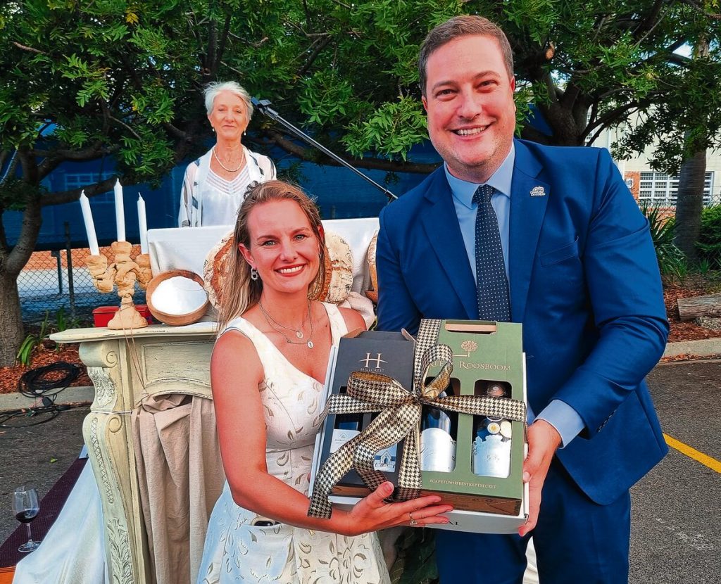 Marné Roos van Klein Roosboom het 'n geskenk aan Geordin Hill-Lewis, Kaapstadse burgemeester, oorhandig. Agter is Georina Westraadt, een van die hooforganiseerders van die geleentheid.