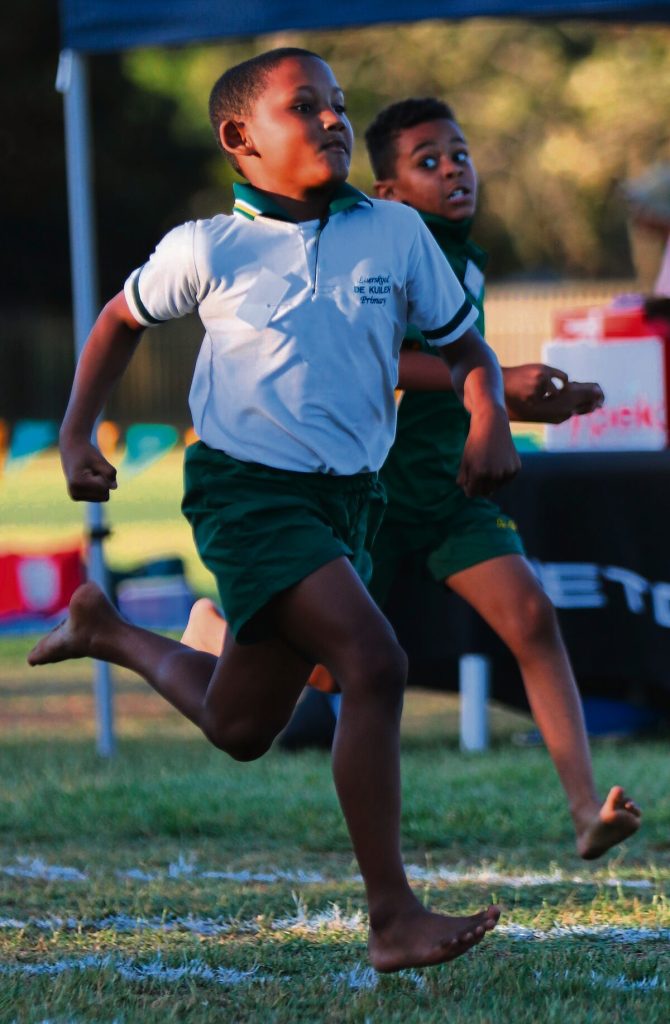 Liam Pylman overtaking in the 100 m, boys u-9. At the back is Zeke Granfield.