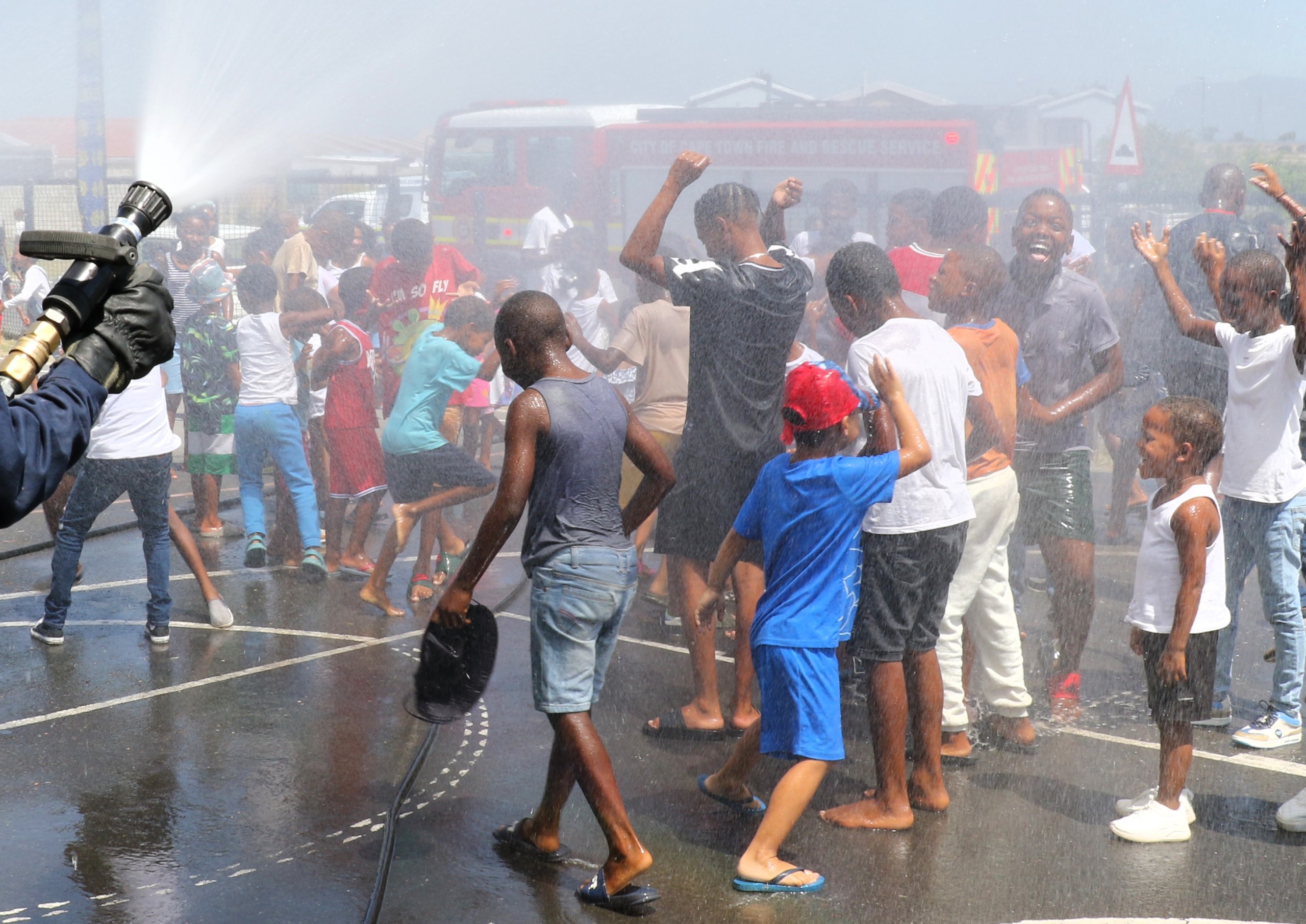 Brandweerbeamptes het die kinders natgespuit vir 'n welkome lafenis op die snikhete dag.