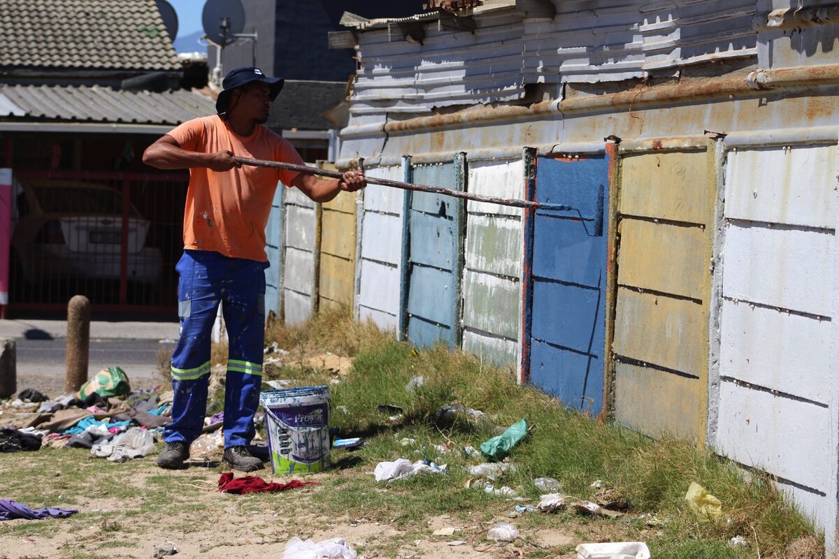 A resident paints over gang tags in Tafelsig