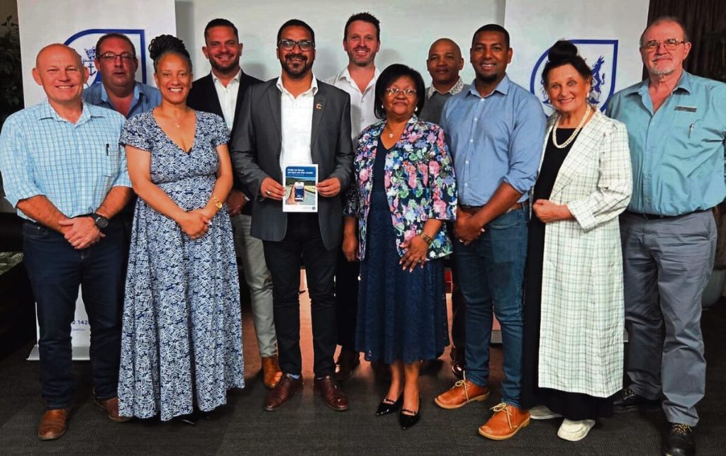 Caption Tertuis Simmers (middle), provincial minister of infrastructure, is here wiht the attendees at the official launch of the Roads4U mobile app. Description