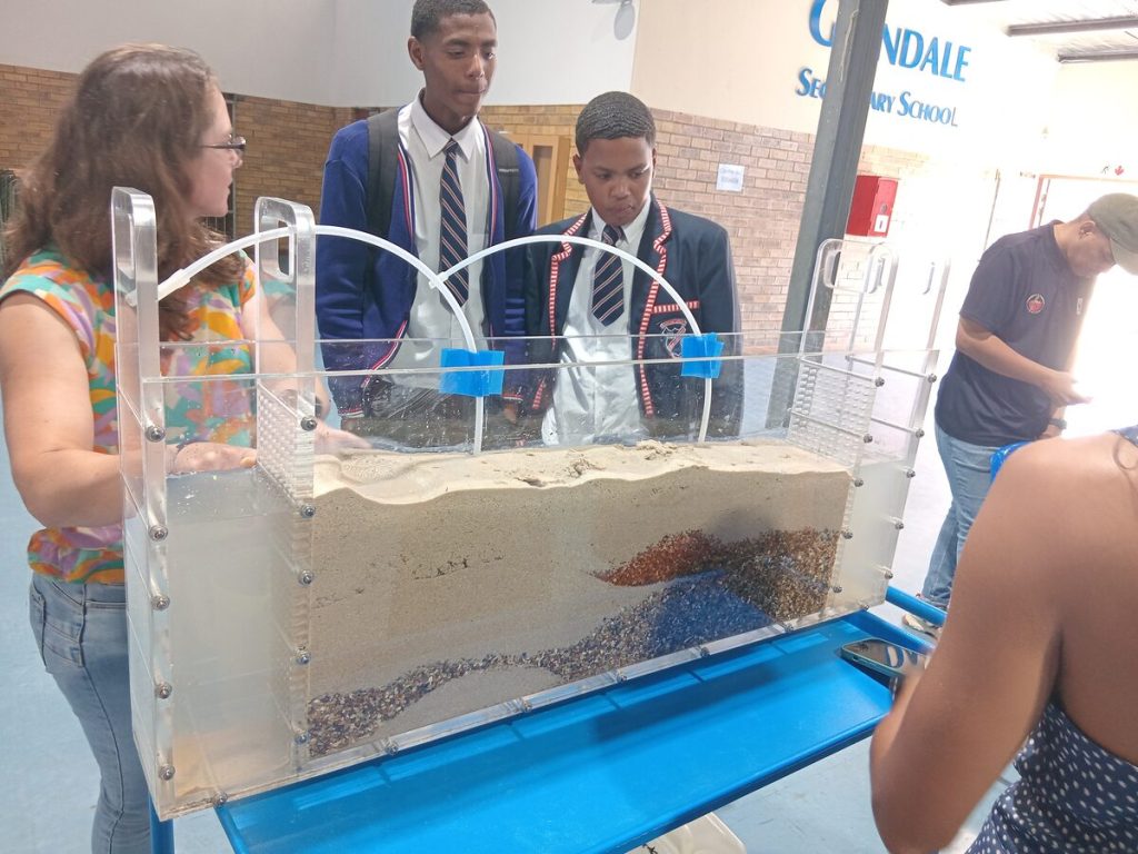 Rachelle Schneuwly of future water shows Glendale High School learners Dylan Damons, grade 12, and Jaydon Cupido, grade 8, how an aquifer filters water.