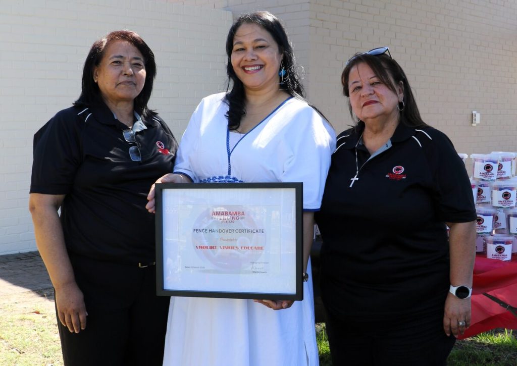 Cicelene Fransman (financial director, Amabamba Fencing), Veronica van de Linde (principal, Vrolike Vinkies) and Sharon Isaacs (managing director, Amambamba Fencing) with a certificate marking the official handover of the fence.