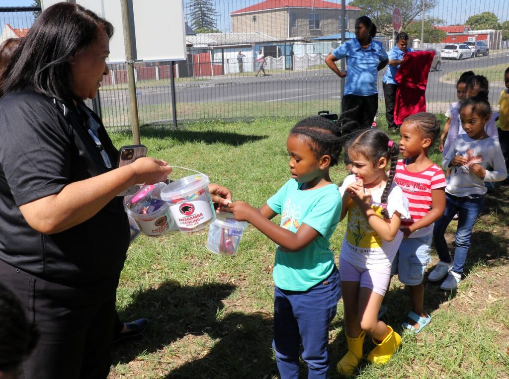 Cicelene Fransman (financial director, Amabamba Fencing) handing out treat buckets to the children courtesy of Amabamba.