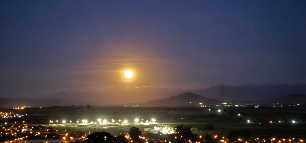 Die volmaan kom oor die Tygervallei, soos gesien van Bracken-natuurreservaat.
