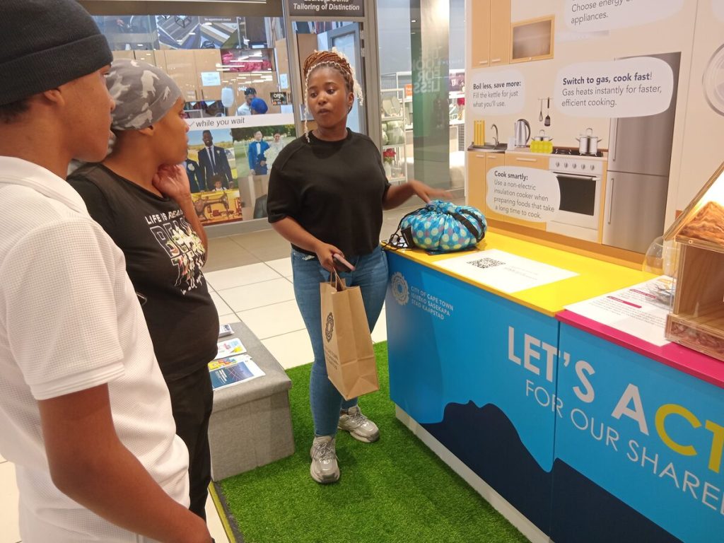 Linathi Sinama explains how hot-bags helps save energy during cooking to Nafeesa Petersen and Anelkha Damons.