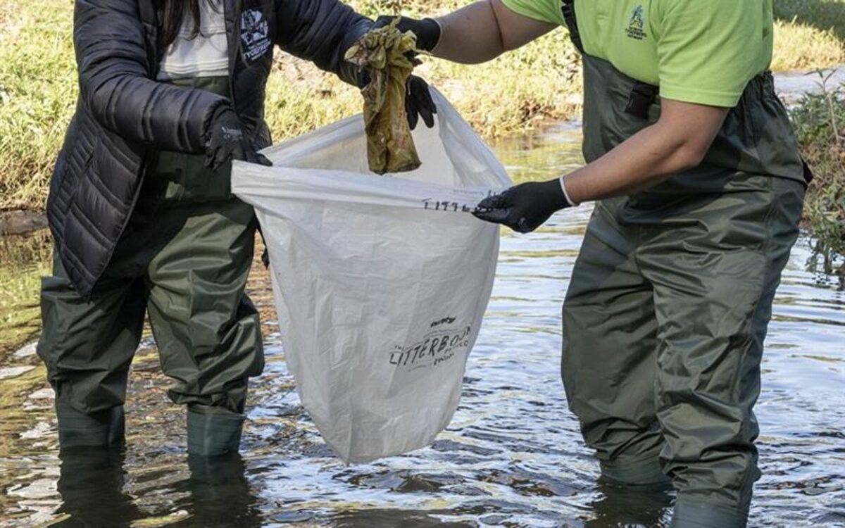 Nasmera Buckus and Noorudeen Roman, representatives from GTP cleaning litter from the Elsieskraal River which runs through Elizabeth Park.