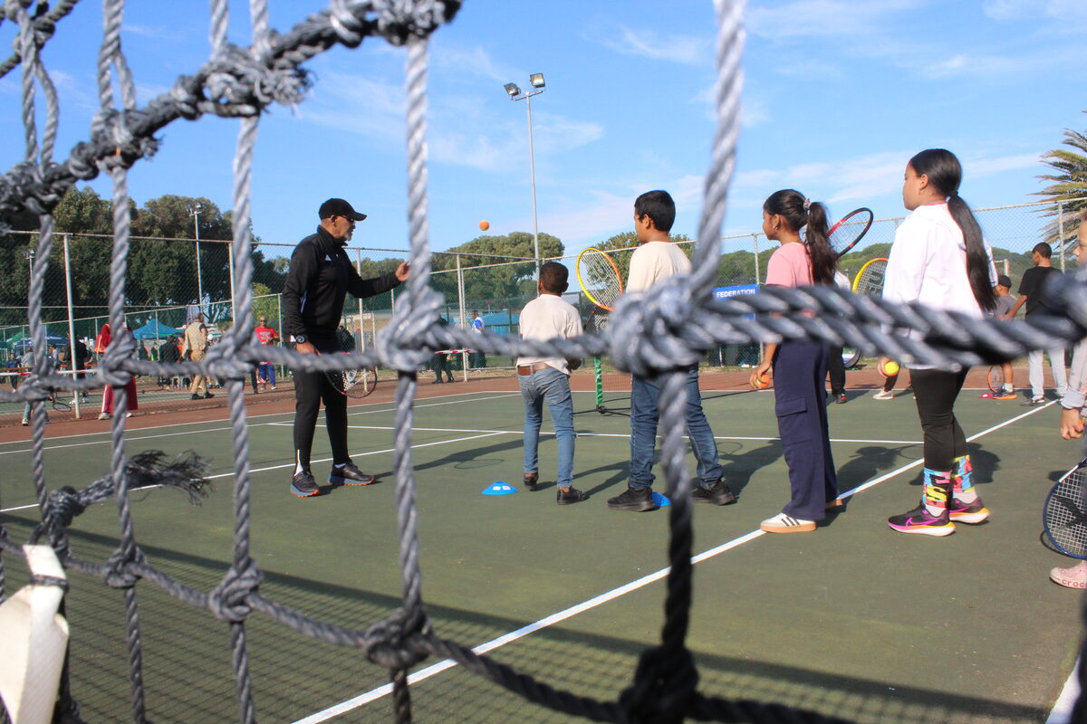 Veteran coach Clifford Swartz teaches children about tennis strokes.