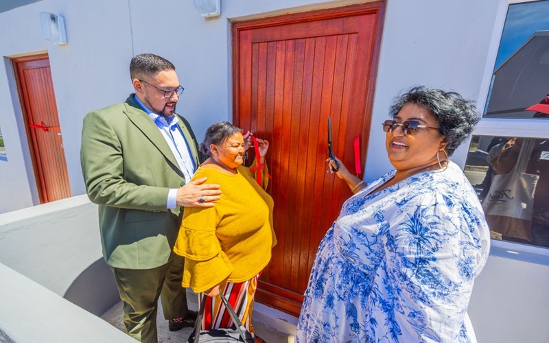 Carl Pophaim (left) and Franchesca Walker (right) hands over the key to Cynthia Markus' house.