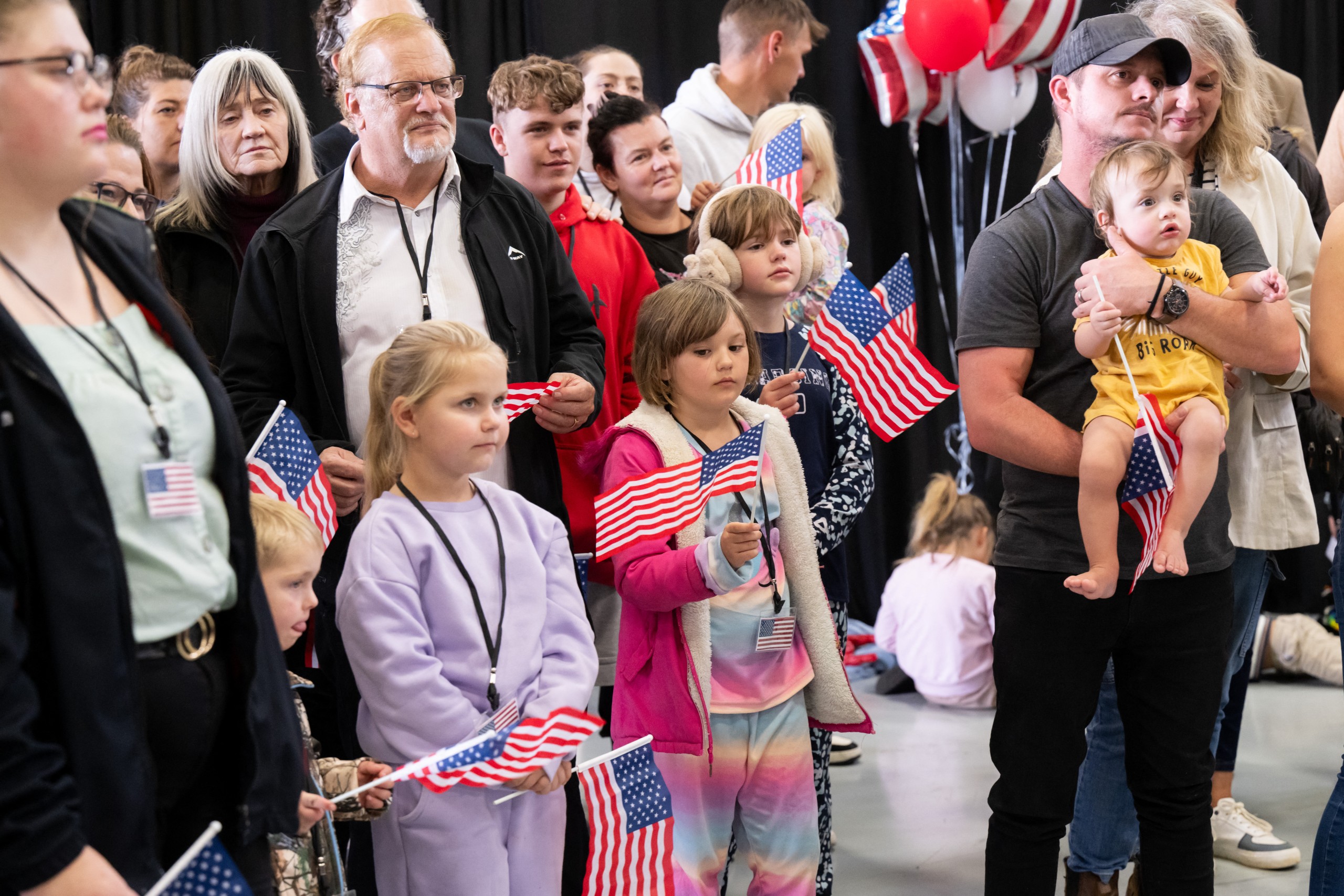The first group of Afrikaners from South Africa to arrive for resettlement listen to remarks from US Deputy Secretary of State Christopher Landau and US Deputy Secretary of Homeland Security Troy Edgar (both out of frame), after they arrived at Washington Dulles International Airport in Dulles, Virginia, on May 12, 2025. President Donald Trump on Monday defended the decision to resettle a group of white Afrikaners in the United States as refugees, saying they were fleeing a "terrible situation" in South Africa. Trump's remarks to reporters at the White House came just hours before an initial group of around 50 Afrikaners was set to arrive at an airport outside Washington.