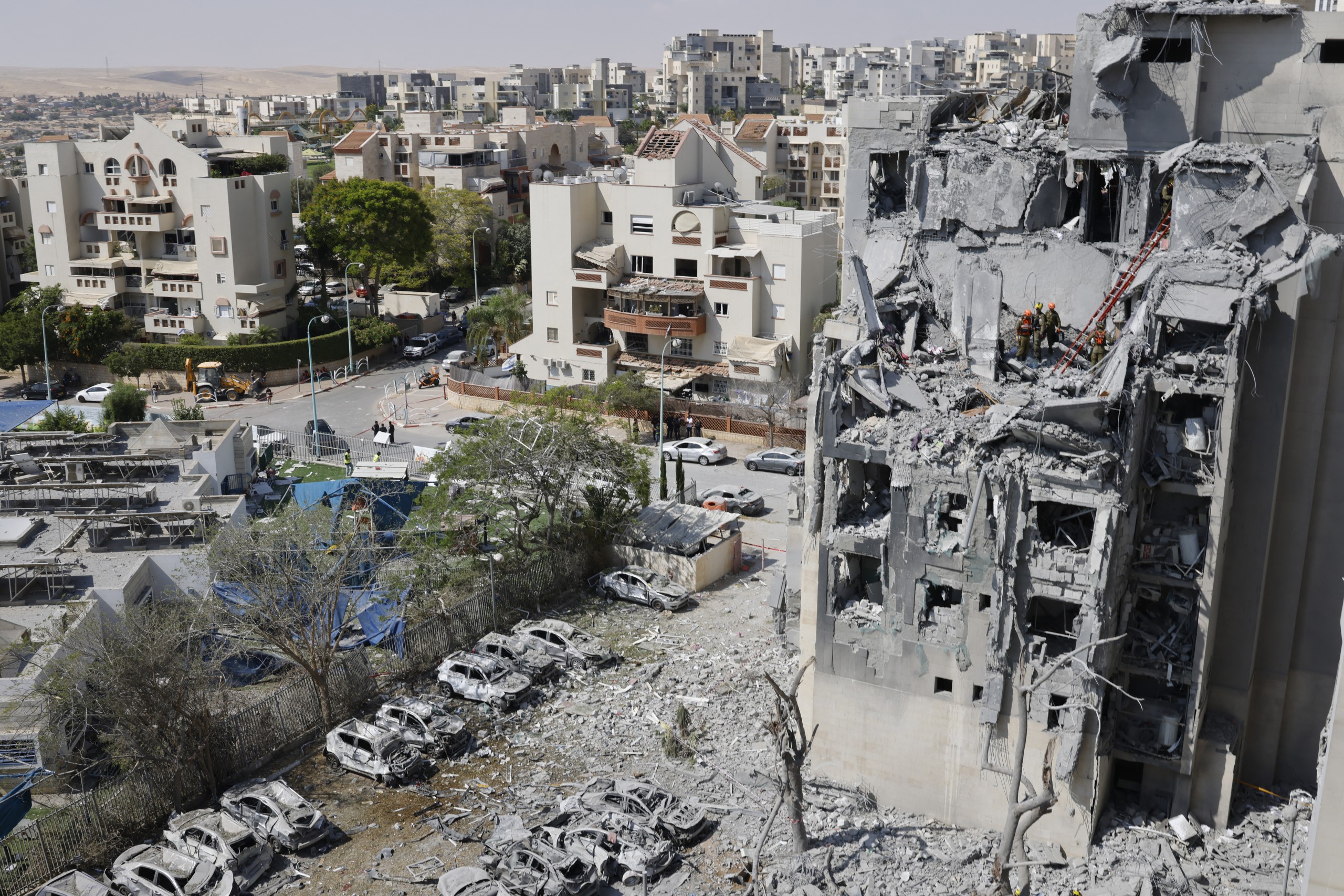 Emergency workers check the damage caused to a building from an Iranian missile strike in Beersheba in southern Israel on 24 June. Israel said on 24 June it had agreed to US President Donald Trump's proposal for a ceasefire with Iran, on the 12th day of war between the foes. PHOTO: John Wessels / AFP