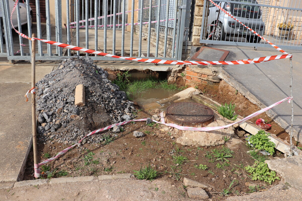 A Fairbridge Heights resident's driveway remains cordoned off and unrepaired over a year after allegedly being damaged by municipal officials, leaving a water-filled hole from the damaged drain.