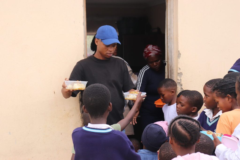 Sivuyile Sardines (Langa Hope and Help chairperson) feeding the children of McNaughton, Kariega after school.