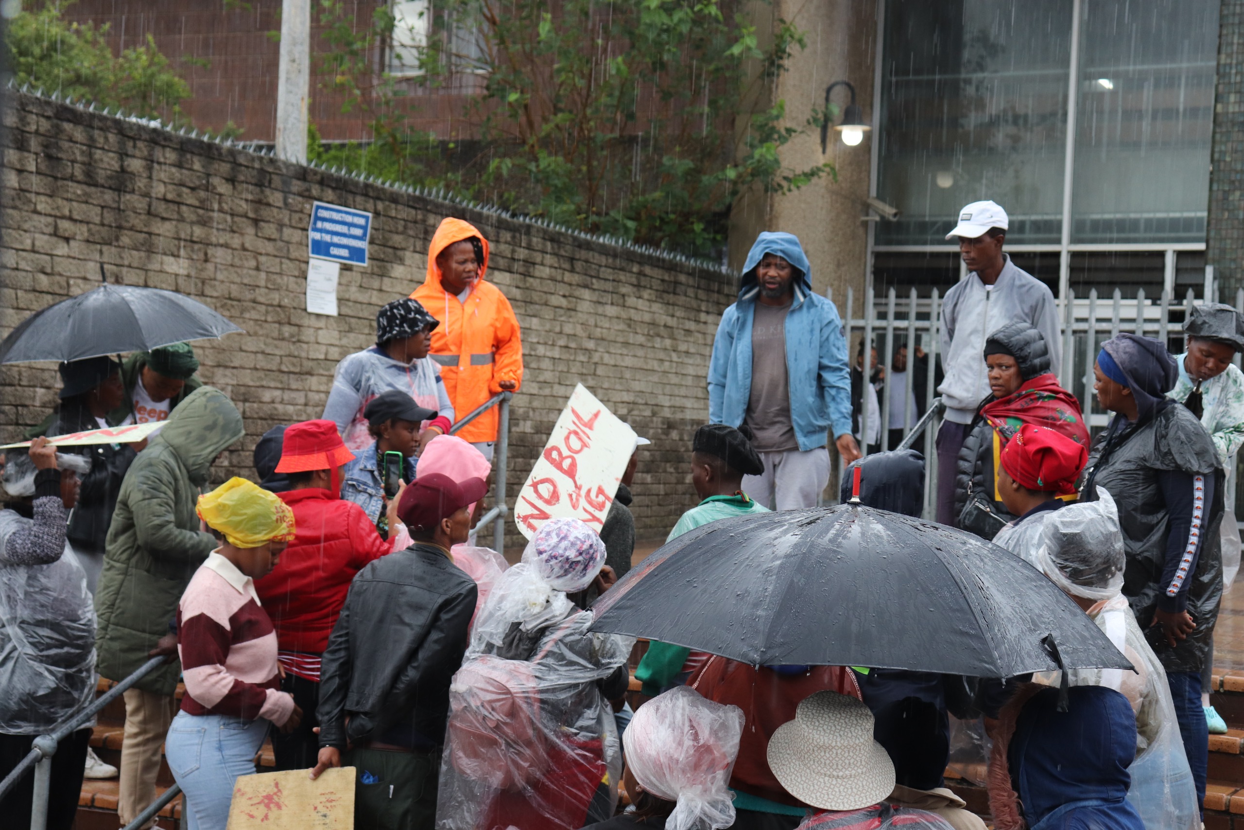 Protesters stood outside the court in the rain, opposing bail.