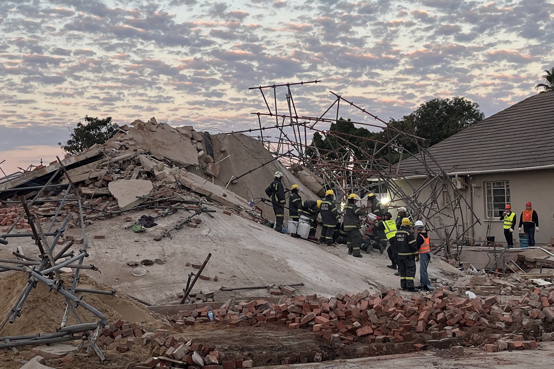 Rescue workers are seen at the scene of a collapsed building in George on 7 May 2024.