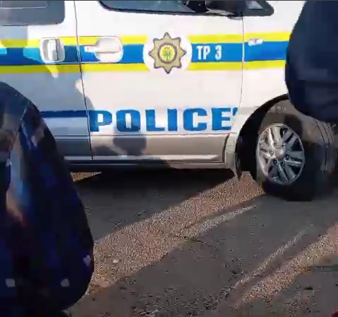 A police vehicle stopped opposite the place where the shot woman lay in the dust.