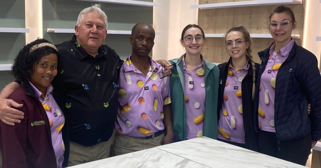 The Sentrum Pharmacy Welkom team of six standing together inside the pharmacy.