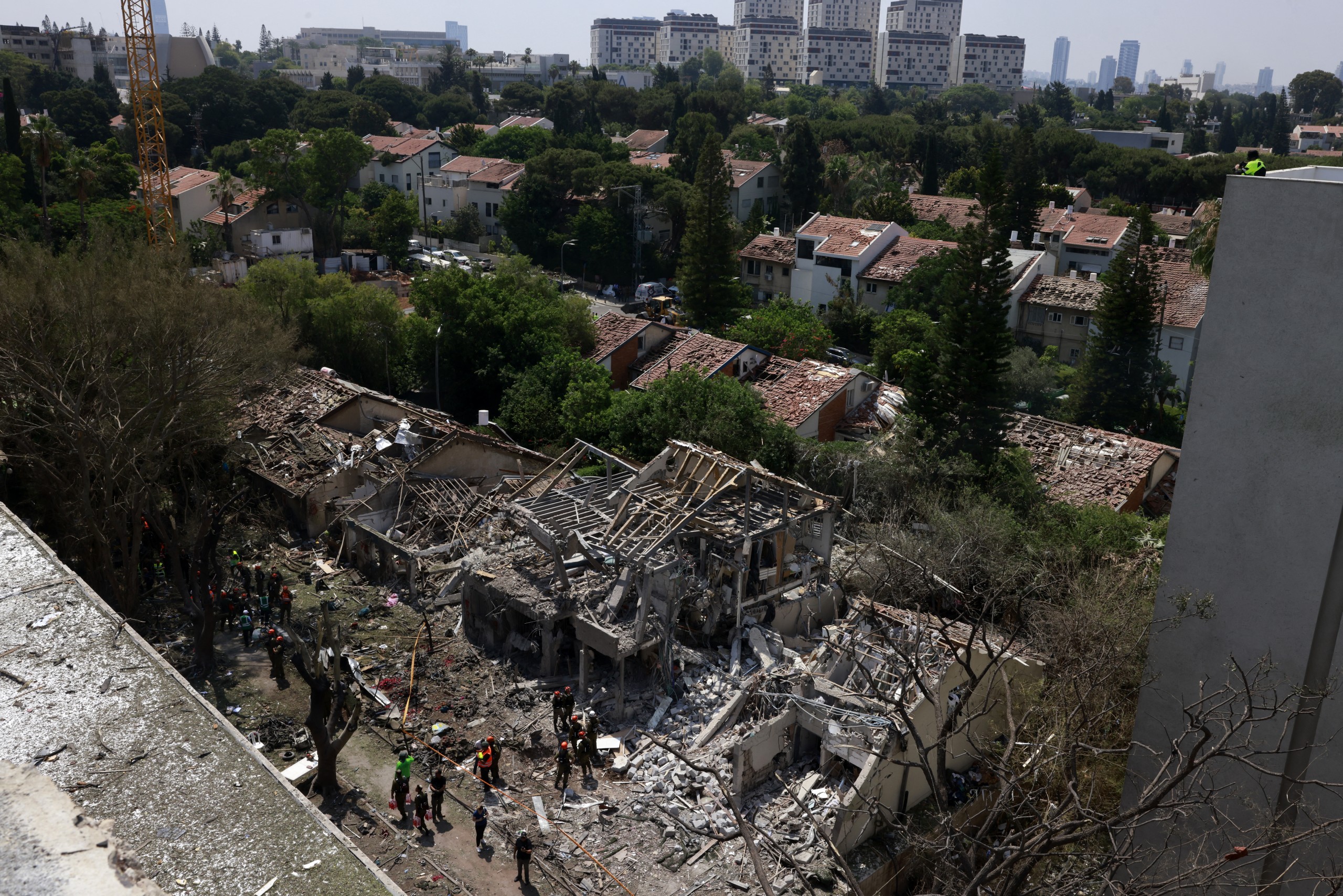 Israeli security forces and first responders gather at the site of an Iranian strike that hit a residential neighbourhood in Tel Aviv this morning (22 June 22). Iran launched two waves of missiles at the country following the US bombing of its nuclear sites. PHOTO: Menahem Kahana / AFP)