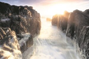 A babbling, rocky seascape at sunset