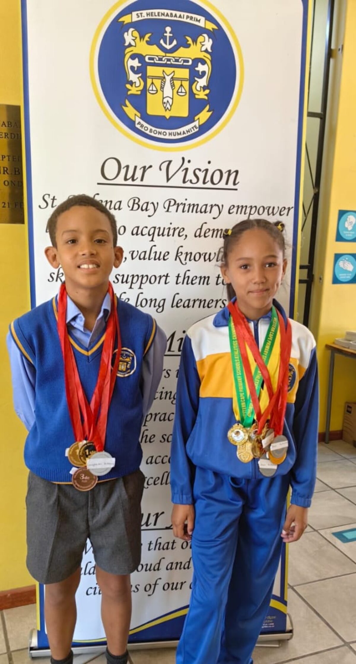 Leighton Erasmus (links) van St. Helenabaai Primêr het in die sesde plek in die o.10-hoogspring vir seuns by die Wes-Kaapse laerskole-atletiek-byeenkoms by Dal Josafat, Paarl, wat Saterdag 1 Maart plaasgevind het, geëindig. By die geleentheid het Ava Adams (regs) ook van St. Helenabaai Primêr uitstekend presteer deur die eerste plek in die 1 200 m te behaal, asook 'n vierde plek in die 100 m en o.10-verspring vir meisies. Ava neem die naweek aan die SA Laerskole atletiek-byeenkoms deel.