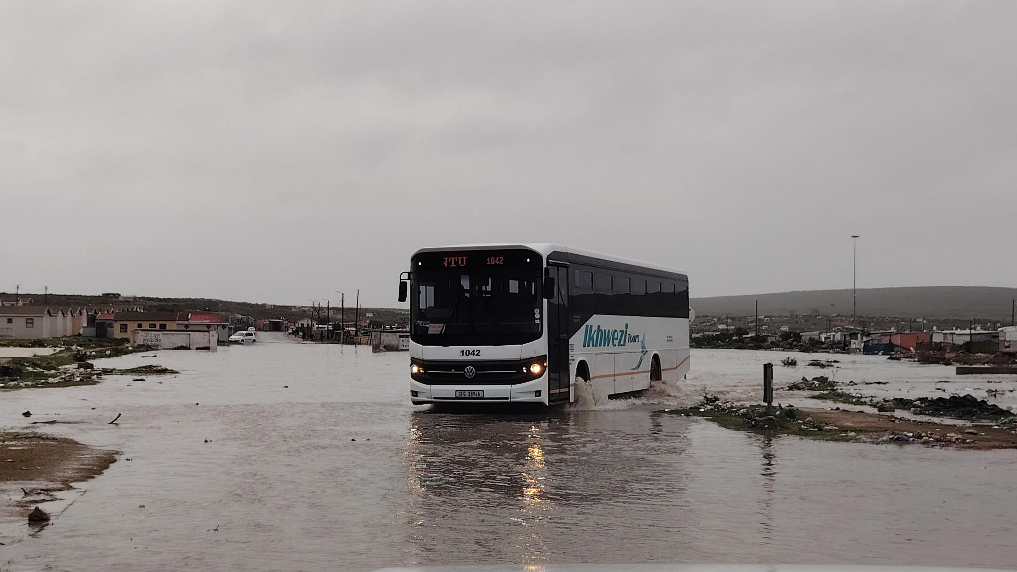 'n Bus sukkel aan deur 'n dam water tussen Diazville en Middelpos in Saldanha. Foto: Saldanhabaai-munisipaliteit