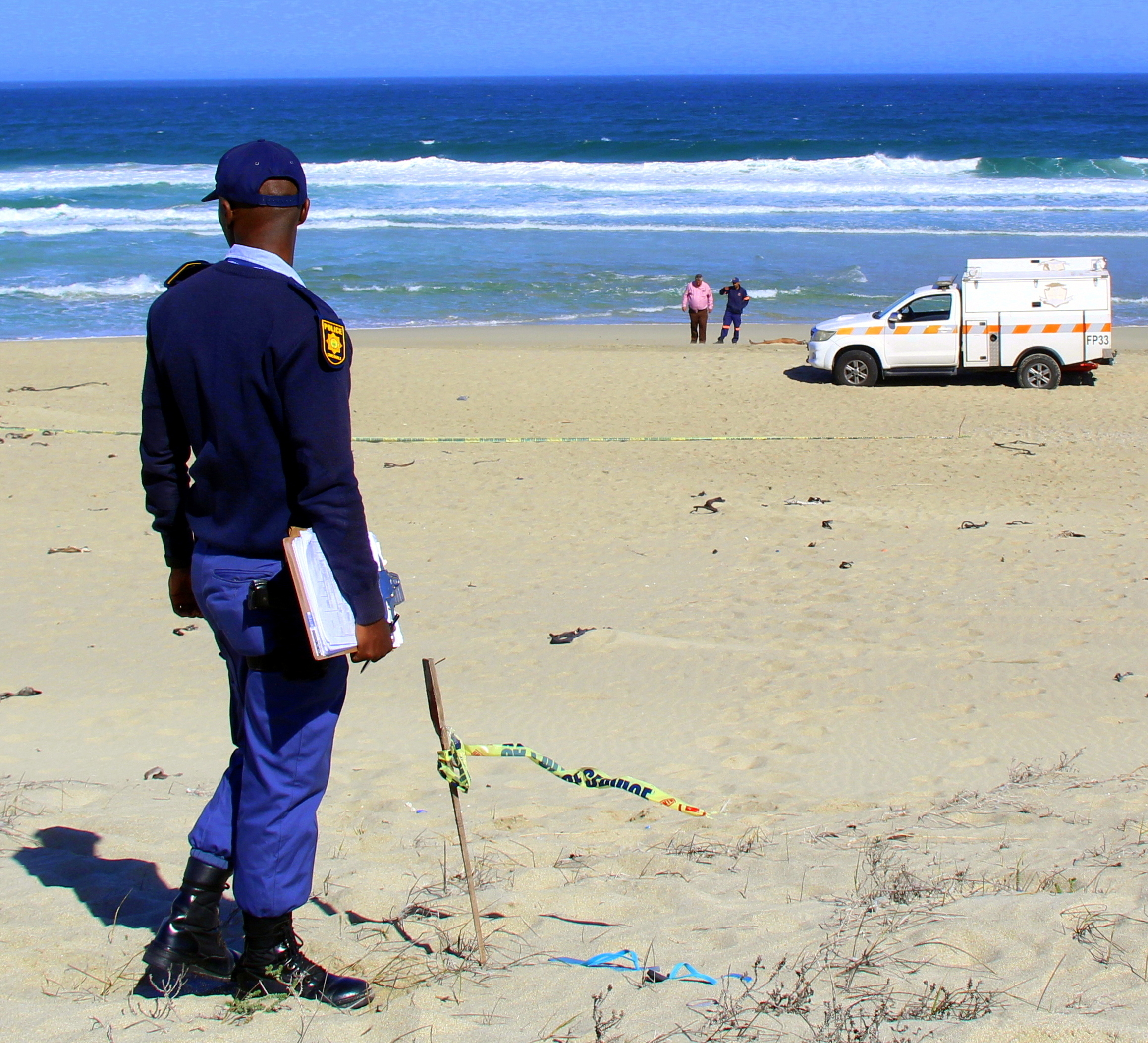 'n Polisieman kyk na die toneel waar 'n lyk op die strand naby die Tabakbaai-vakansieoord gekry is. Foto: Alida Buckle