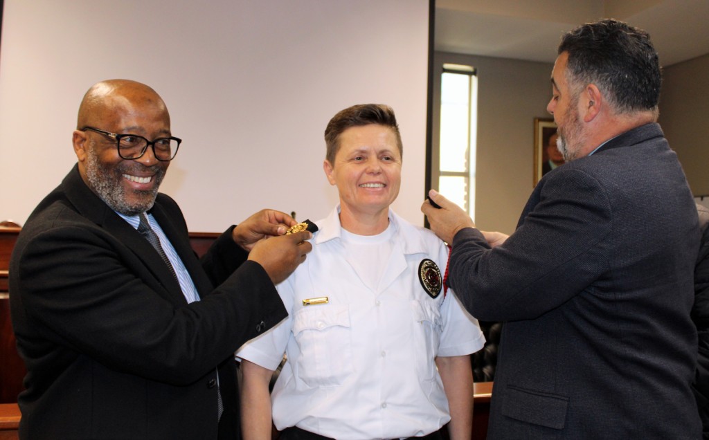 Ann Supra-Vertue (middel) se lapelle met haar nuwe rang word aangesit deur Pumi Mbaliswana, Direkteur: Korporatiewe en Openbare Veiligheidsdienste, en André Truter, uitvoerende burgemeester. Foto: Alida Buckle