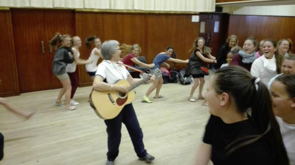 Aan die begelei met haar kitaar. 