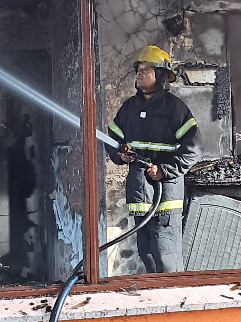 Brandweerman Leon Carolus besig om die vlamme te spuit. Foto: Alida Buckle