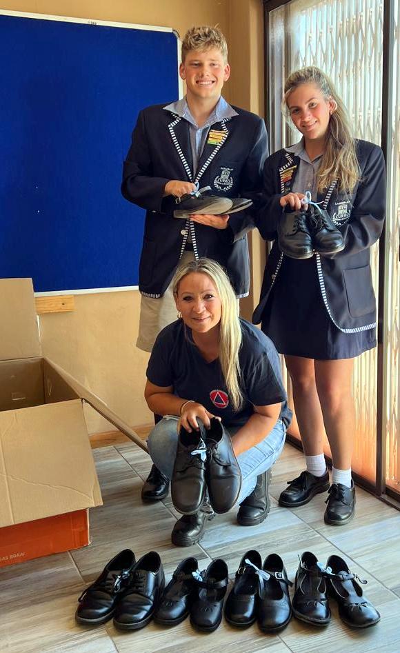Carol Ferris van ramprisikobestuur (voor) saam met Curro-leerders Myles Butti en Tyler Meiring.