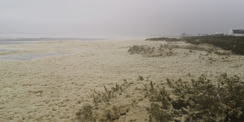 Die strand voor Paternoster toe met skuim weens stormagtige waters. Foto: Danie Hefers